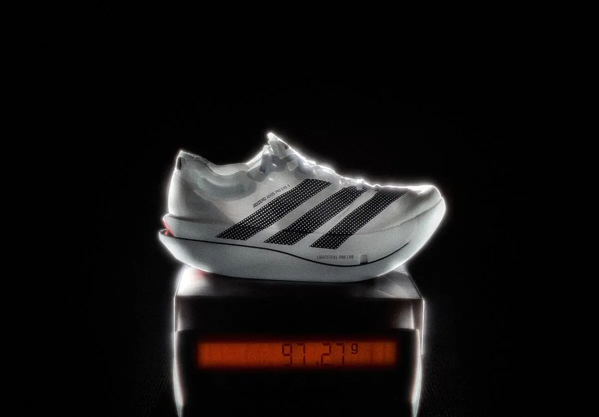 Adidas Adizero Adios Pro Evo 3 on a digital scale, whose display reads 97.27 grams.