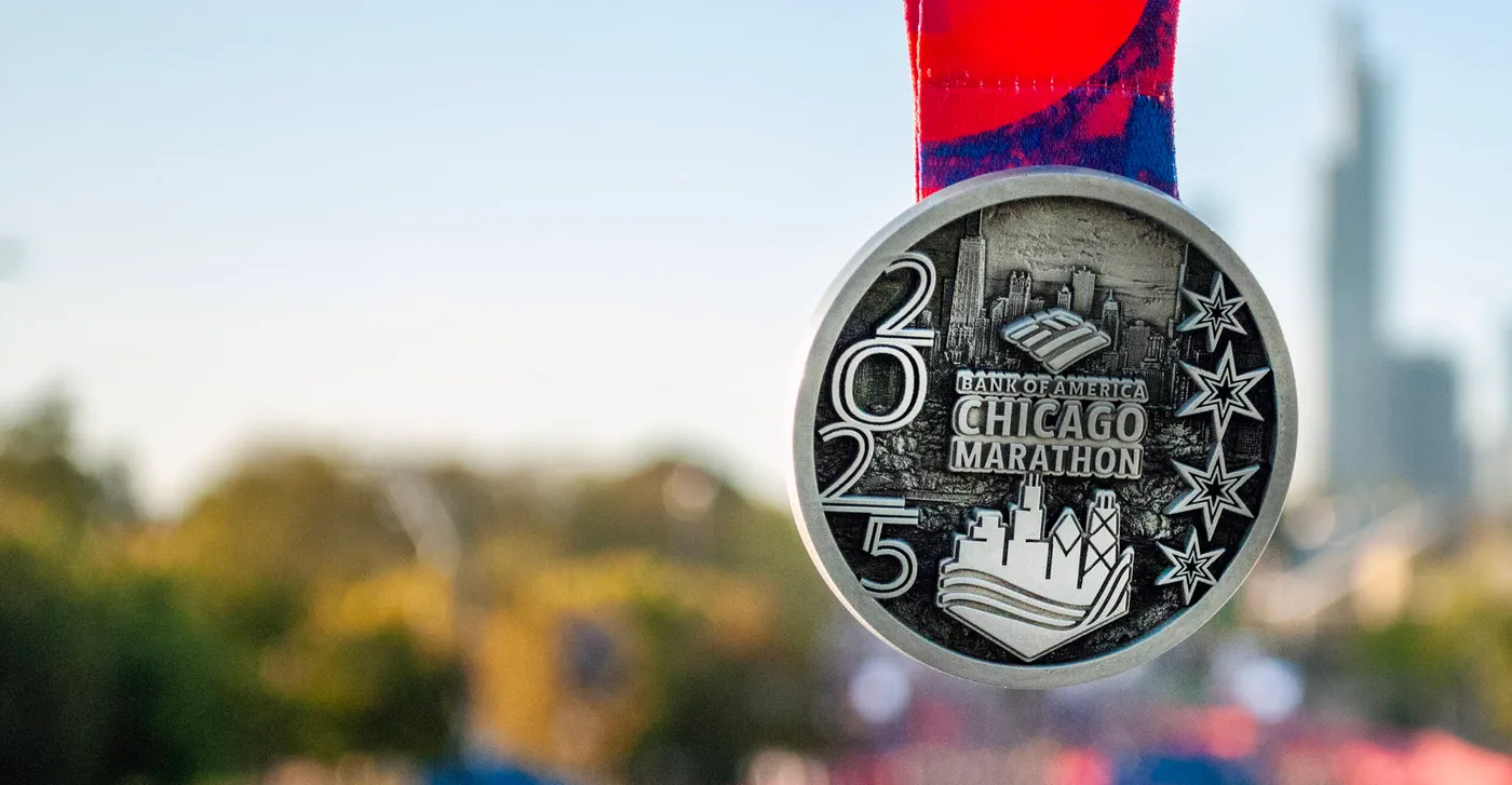 The 2025 Chicago Marathon medal, silver with the skyline and the stars of the city flag.